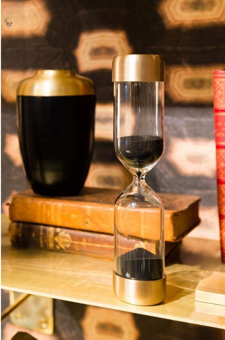 Satin brass and black sand timer as decorative in living room